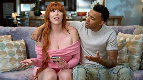 A busty redhead stepmom rewards her attentive stepson on the couch