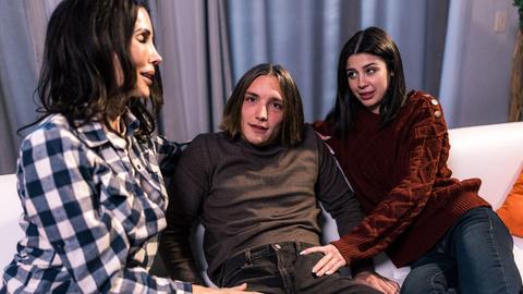 Two hot brunettes share a big cock on the couch